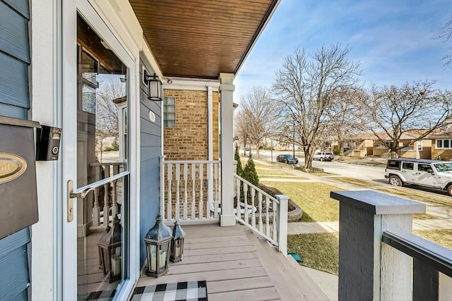 wooden terrace featuring a residential view and covered porch