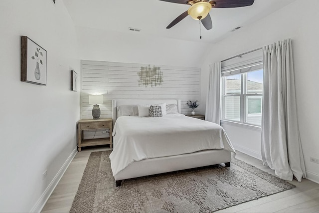 bedroom featuring visible vents, baseboards, light wood-type flooring, and a ceiling fan