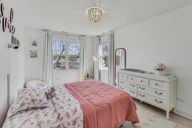 bedroom featuring light wood-type flooring and baseboards