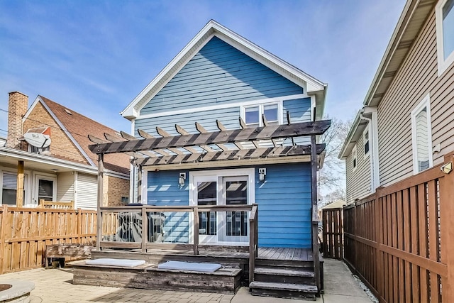 back of property featuring fence, a pergola, and a wooden deck