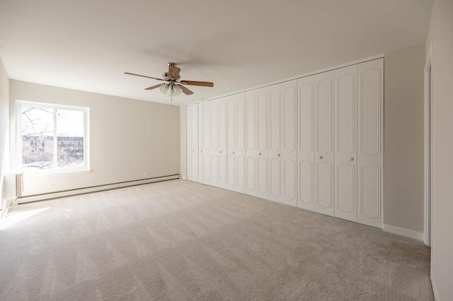 unfurnished bedroom with baseboard heating, ceiling fan, and carpet floors