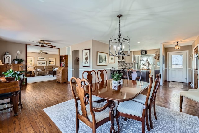 dining space featuring visible vents, hardwood / wood-style floors, and ceiling fan with notable chandelier