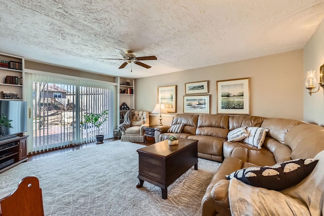 living room with ceiling fan, built in shelves, a textured ceiling, and carpet flooring