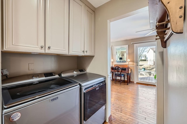 clothes washing area featuring ceiling fan, light wood-style floors, cabinet space, and washer and dryer