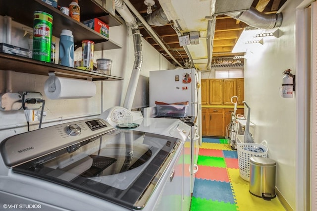 washroom with washer and dryer and baseboards