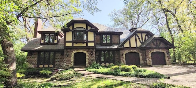 27W161 Mack Rd, Wheaton, IL 60189 - english style home with driveway, a chimney, a garage, brick siding, and stucco siding