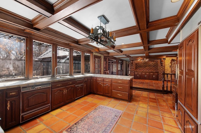 kitchen featuring beamed ceiling, a notable chandelier, a sink, coffered ceiling, and a peninsula