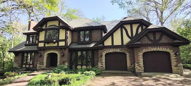 27W161 Mack Rd, Wheaton, IL 60189 - english style home with decorative driveway, stucco siding, a garage, a chimney, and brick siding