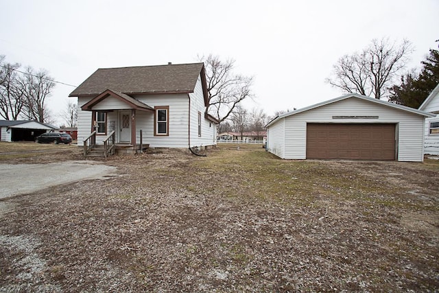 bungalow featuring roof with shingles, an outdoor structure, and a detached garage