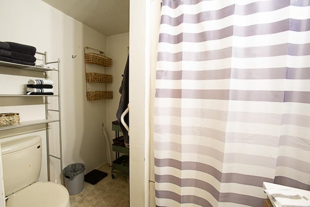 bathroom featuring tile patterned flooring, a shower with curtain, and toilet