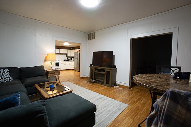 living room with visible vents and light wood-style floors