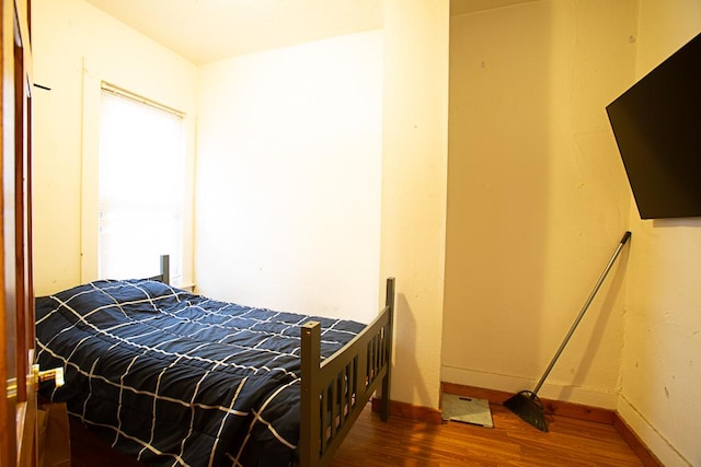 bedroom with baseboards and wood finished floors