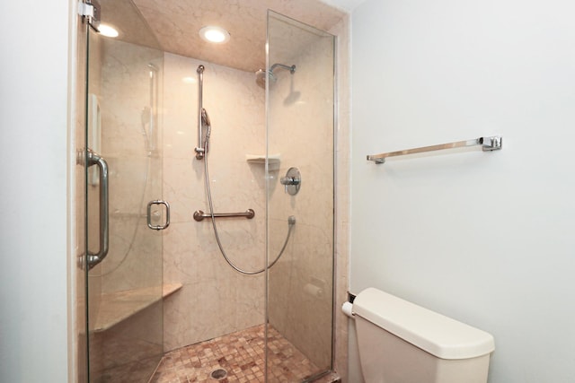 bathroom featuring toilet, a stall shower, and recessed lighting