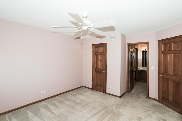 unfurnished bedroom with visible vents, baseboards, a ceiling fan, and light colored carpet