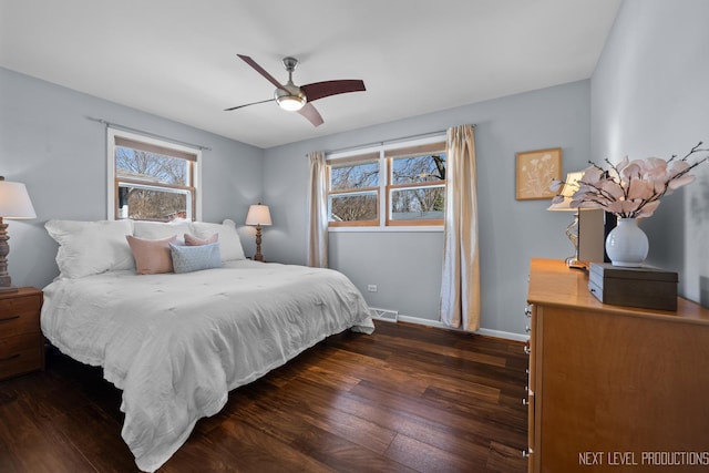 bedroom with ceiling fan, visible vents, baseboards, and wood finished floors