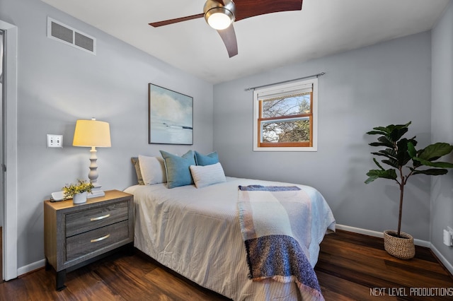 bedroom with dark wood finished floors, baseboards, visible vents, and a ceiling fan