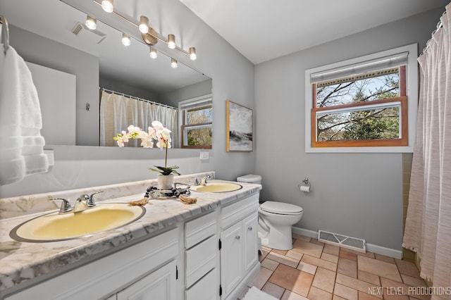 bathroom featuring visible vents, baseboards, and a sink