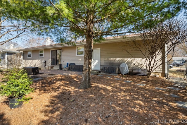 rear view of house with a patio, central AC unit, and fence