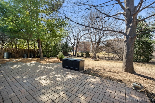 view of patio / terrace featuring a jacuzzi and fence