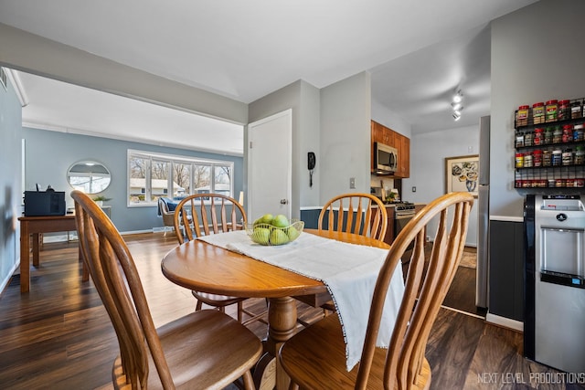 dining room featuring dark wood finished floors and baseboards