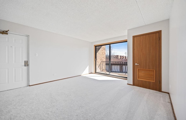 carpeted empty room featuring a textured ceiling, visible vents, and baseboards