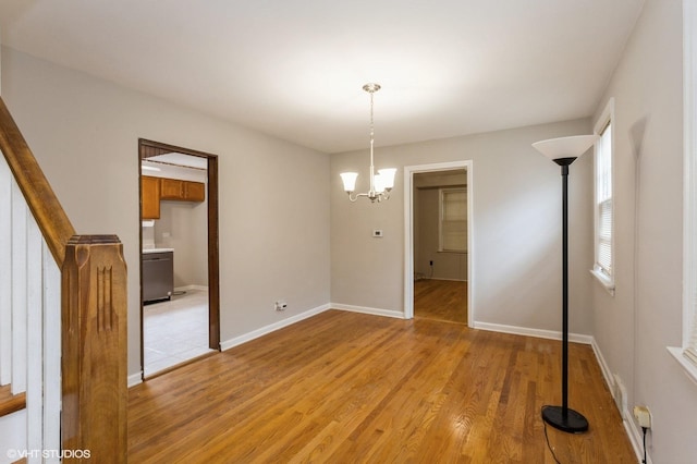6118 N Kimball Ave, Chicago, IL 60659 - empty room featuring an inviting chandelier, stairs, light wood finished floors, and baseboards