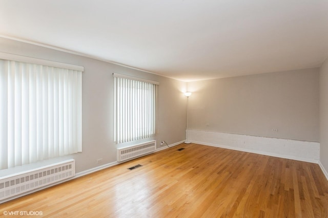 6118 N Kimball Ave, Chicago, IL 60659 - spare room featuring radiator heating unit, baseboards, wood finished floors, and visible vents