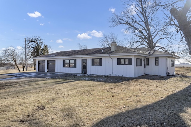 view of front of house featuring a garage, driveway, and a chimney