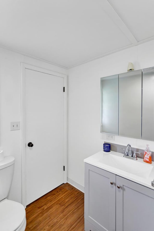 bathroom with vanity, wood finished floors, and toilet