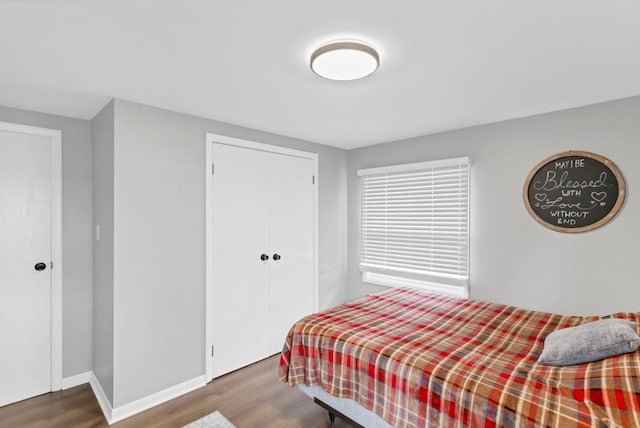 bedroom featuring a closet, wood finished floors, and baseboards