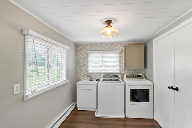 laundry area featuring dark wood-style floors, cabinet space, a sink, washer and dryer, and baseboards