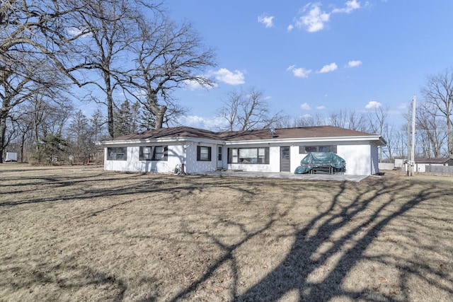 ranch-style house with a patio area and a front lawn