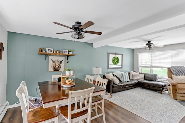 dining space with dark wood-style floors, baseboard heating, and a ceiling fan