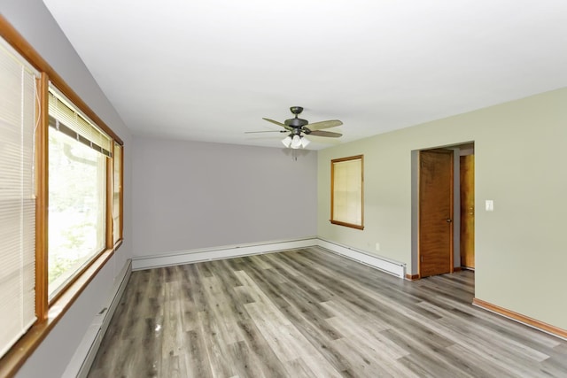 empty room with a baseboard heating unit, light wood-style floors, baseboards, and ceiling fan