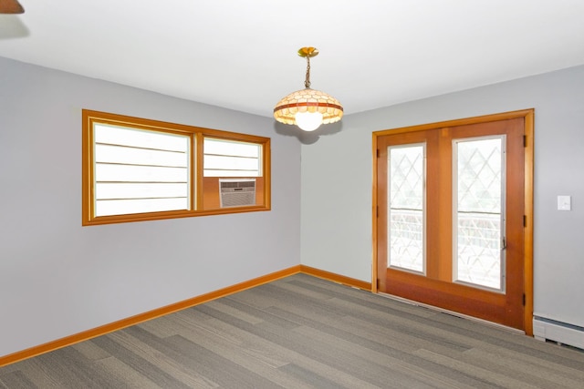 spare room with baseboard heating, cooling unit, carpet flooring, and baseboards