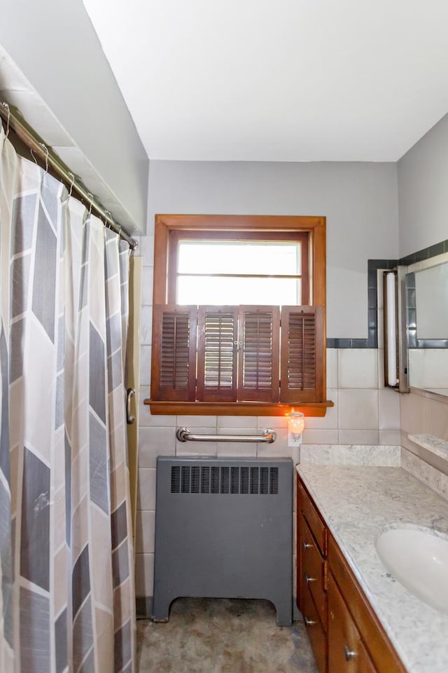 bathroom with tile walls, a shower with shower curtain, vanity, and radiator