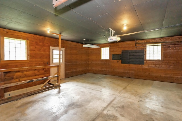 garage featuring wood walls and a garage door opener