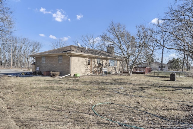 view of side of property with brick siding and a chimney