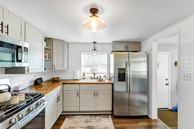 kitchen with stainless steel appliances, dark wood-type flooring, a sink, backsplash, and open shelves