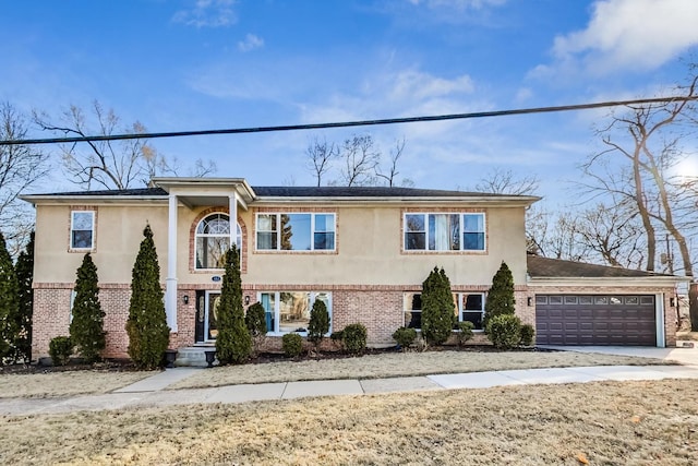 view of front of home featuring an attached garage, brick siding, and stucco siding