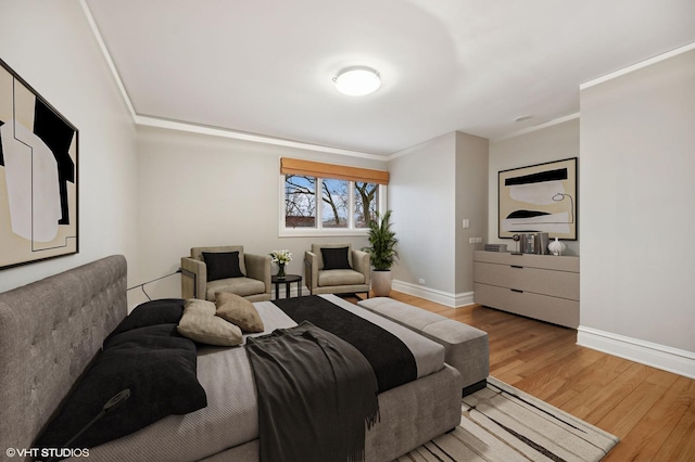 bedroom featuring ornamental molding, wood finished floors, and baseboards