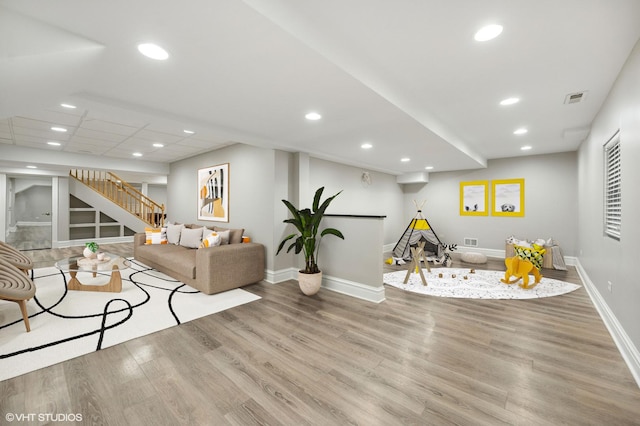 living room featuring recessed lighting, visible vents, wood finished floors, baseboards, and stairs