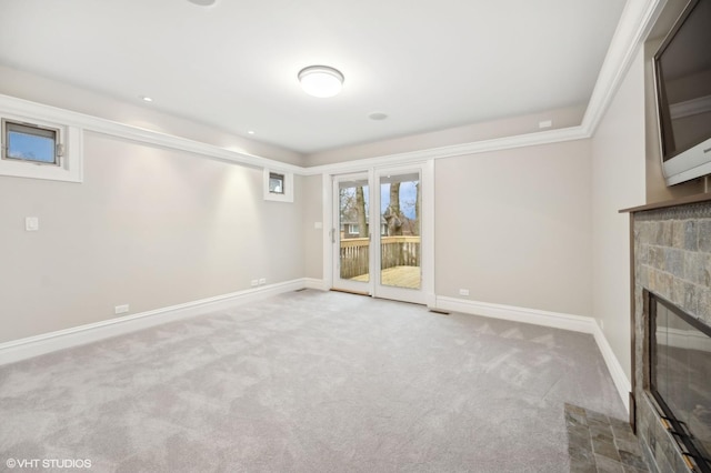 unfurnished living room with carpet floors, a glass covered fireplace, and baseboards