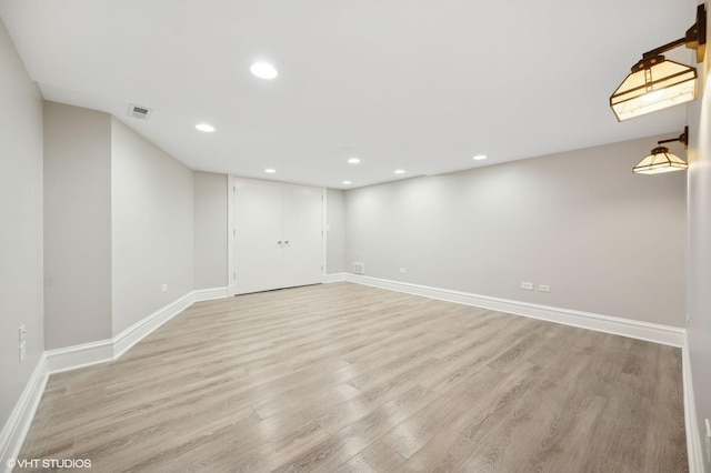 spare room featuring light wood-style floors, recessed lighting, and baseboards