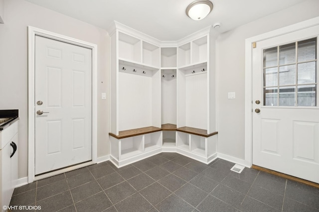 mudroom featuring dark tile patterned flooring, visible vents, and baseboards