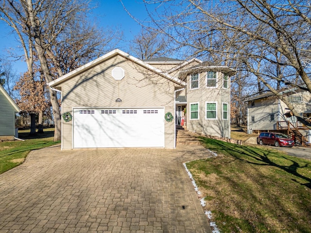 traditional home featuring a garage, a front yard, and decorative driveway