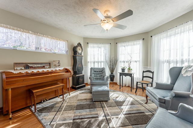 sitting room featuring ceiling fan, a textured ceiling, and wood finished floors