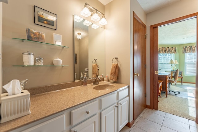 bathroom featuring a textured ceiling, tile patterned flooring, vanity, and baseboards