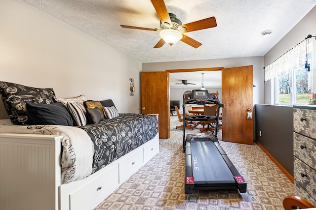 bedroom with a ceiling fan and a textured ceiling