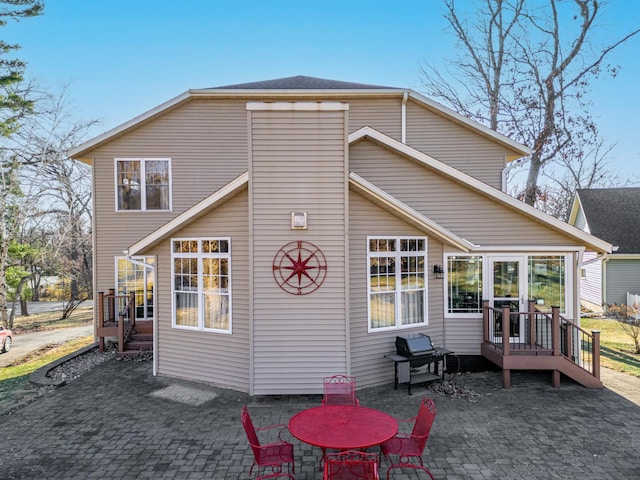 back of property featuring a patio area and a wooden deck